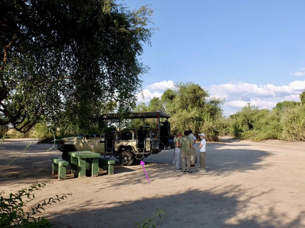  An evening game drive &amp; a stop for G &amp; T’s...beside Land Cruiser in Chobi Nat’l Park, Chobi River, Kasane, Botswana.  Despite people’s concerns about my left leg, I had no trouble getting up &amp; down that ladder (see purple arrow) to our s