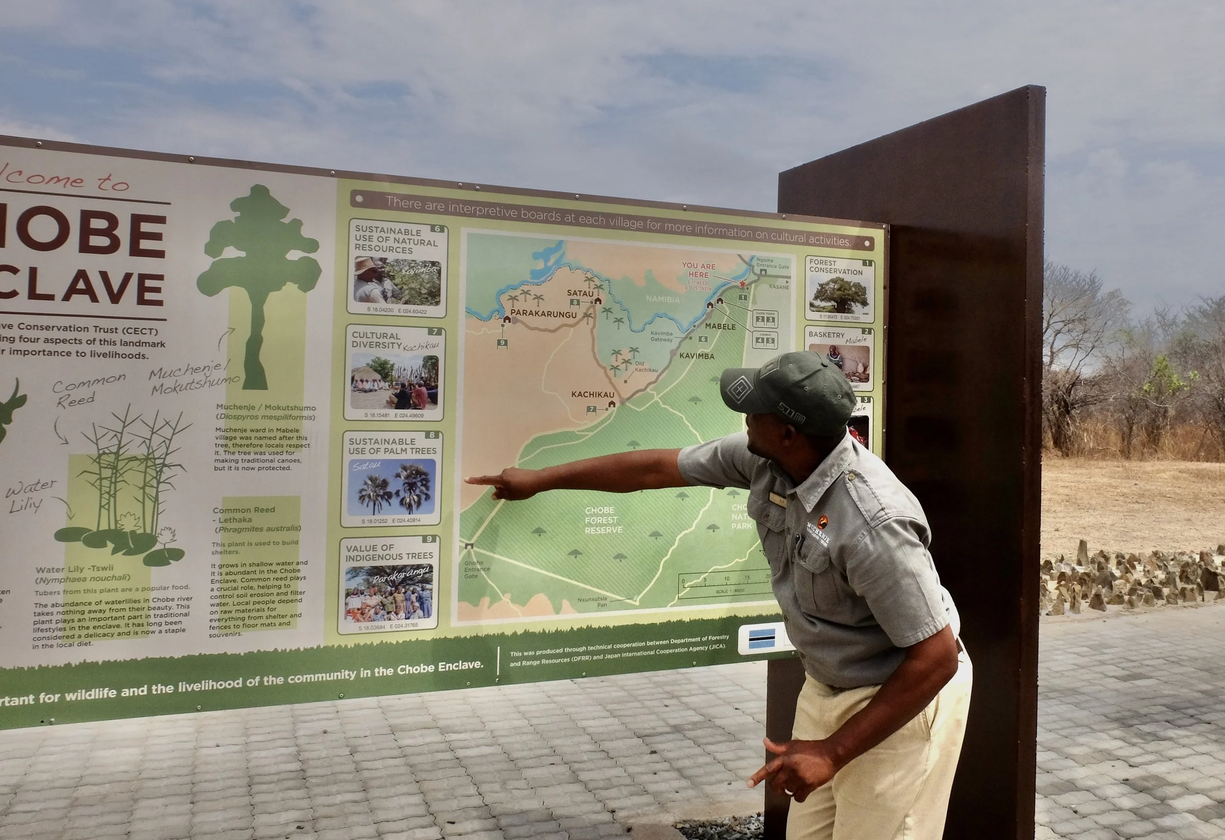  One day, K.B. took us on a trip to the Chobi Enclave &amp; the Mabela Primary school.  He made sure that we understood where we were headed.  The embedded rocks behind K.B. are to keep elephants out of the signage area. 