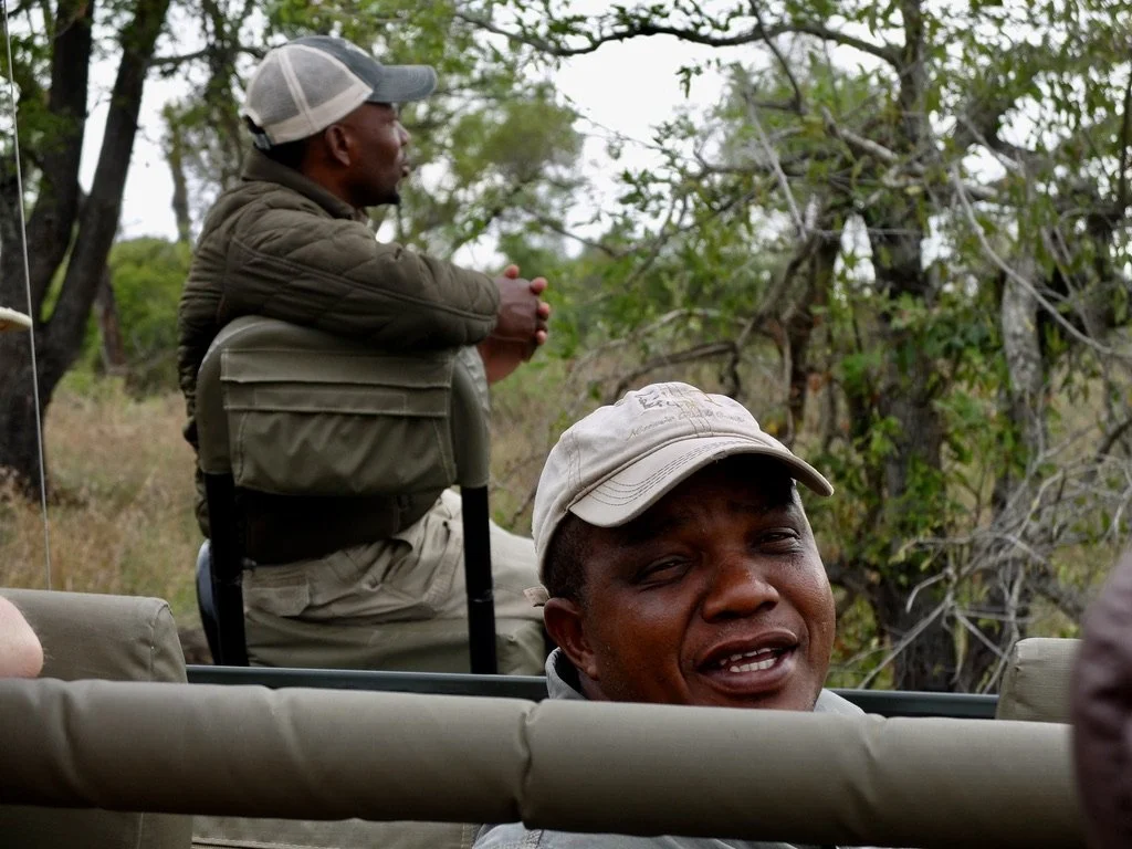  Our driver/guide Tinyko.  Sitting, unseat-belted on the bonnet is our tracker/spotter, Wonder.   Notten's Bush Camp, Sabi Sands Nature Preserve, South Africa. 