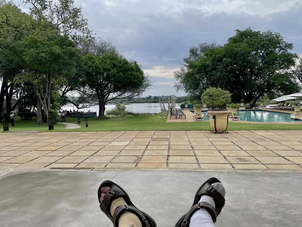  At a fancy hotel on the Zambezi River leading into Victoria Falls, Zambia. I was minding my own business waiting to be driven to the Victoria Falls Royal Steam Train dinner tour when… 