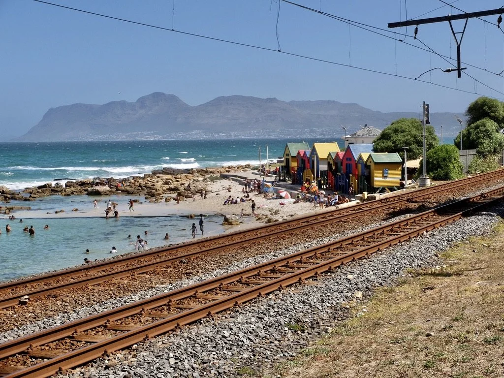  Colourful bathing boxes where the bay is closed off allowing calm swimming.  Since the end of apartheid, folks from the crowded settlements can now come here, by car or on the interurban rail line to rent a bathing box for the day at Kalk Bay.  