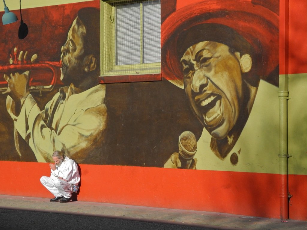  “Not just the mural...”  I am attracted to outdoor art. Here the squatting guy in white made the photo. Nikon Cool Pix P7100. 