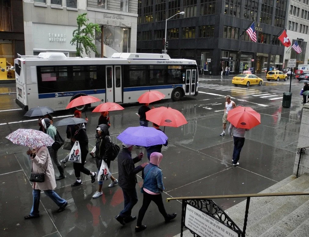  Umbrellas in the rain from the steps of St. Thomas Church’s Fifth Ave. entrance.   I saw the colorful umbrellas &amp; clambered up the steps &amp; turned around just as the photo composed itself.  iPhone X. 