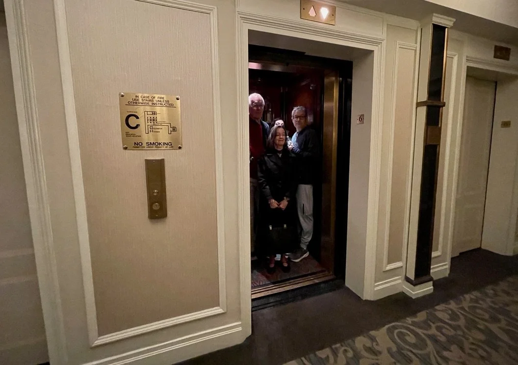  At about 9:00 AM it was "rush hour" at the West 54th St. Warwick Hotel.  We were on the 6th floor &amp; we sometimes had to wait 15-20 to get on an elevator.  Going down to check out, Nomi got on an elevator &amp; I waited another ten minutes to squ