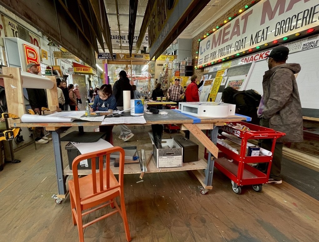  Before the Noble SIgns tour started, they gave that girl a project &amp; then displayed it on that white magnetic board to the right of the fellow in purple tie dye in the next slide. 