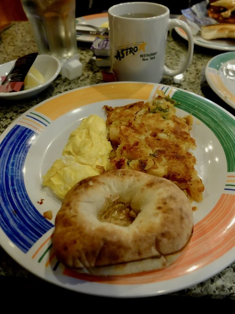  Breakfast with a bialy.    ASTRO Restaurant, 6th Avenue (of the Americas) &amp; 55th St., NY,NY., diagonally across the street from the Warwick. 