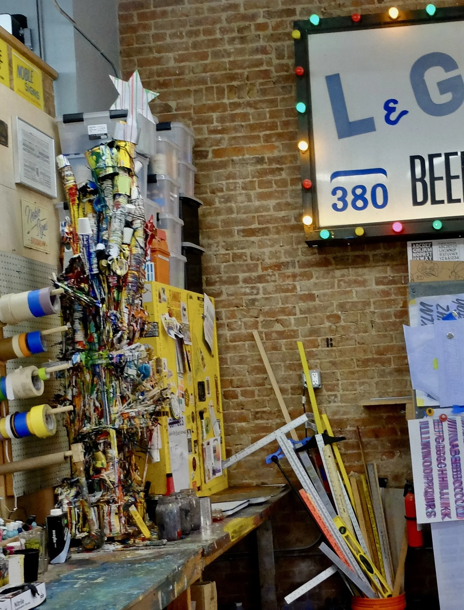  Their painter from time to time attaches things he painted onto the stand.  At Christmas time they put lights around it &amp; a star on top.  I liked all the rulers in the can. I thought they too were a sculpture but, they’re used.  Noble Signs Desi