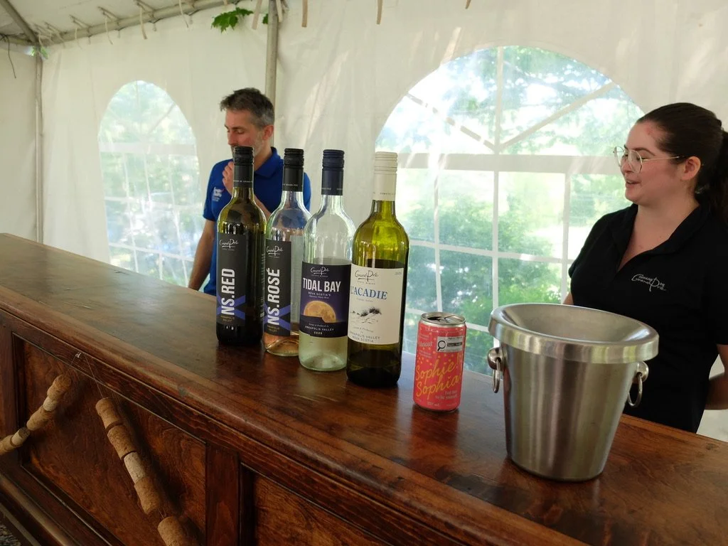  Domaine de Grand Pré Vineyards, Nova Scotia. The hostess who was excellent &amp; our driver JD.  Tidal Bay is an appellation of two valleys here.  Note the non- alcoholic choice.  The three vineyards we visited had their vintages of non-alcoholic be