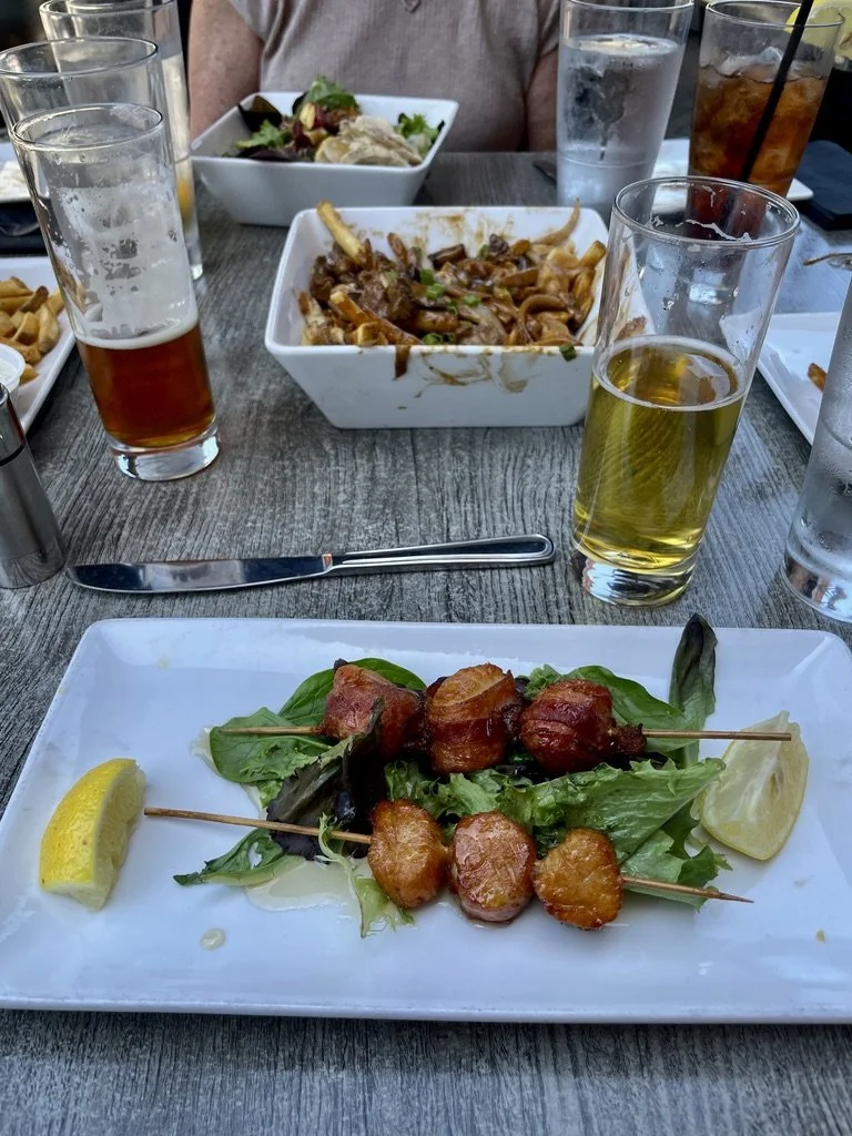  Bacon wrapped scallops with maple bourbon glaze.  We had to try the Canadian specialty of poutine.  In this case, tenderloin tip poutine was best shared with four people.  “Local beef tenderloin tips sautéed with Spanish onions, mushroom medley, Que