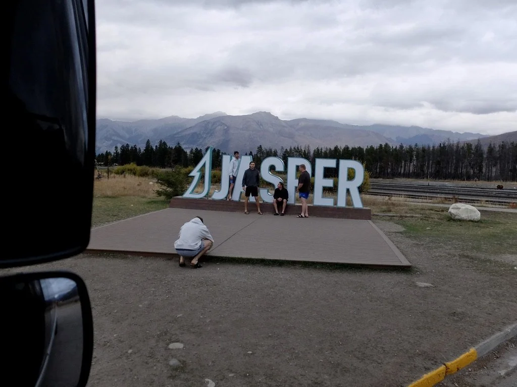  Some local kids in Jasper.  One guy gave me his phone &amp; asked me to take a photo.  Dave then jokingly drove off with me holding the guy’s phone.  Dave said that the new sign allows tourists to know where they are. 