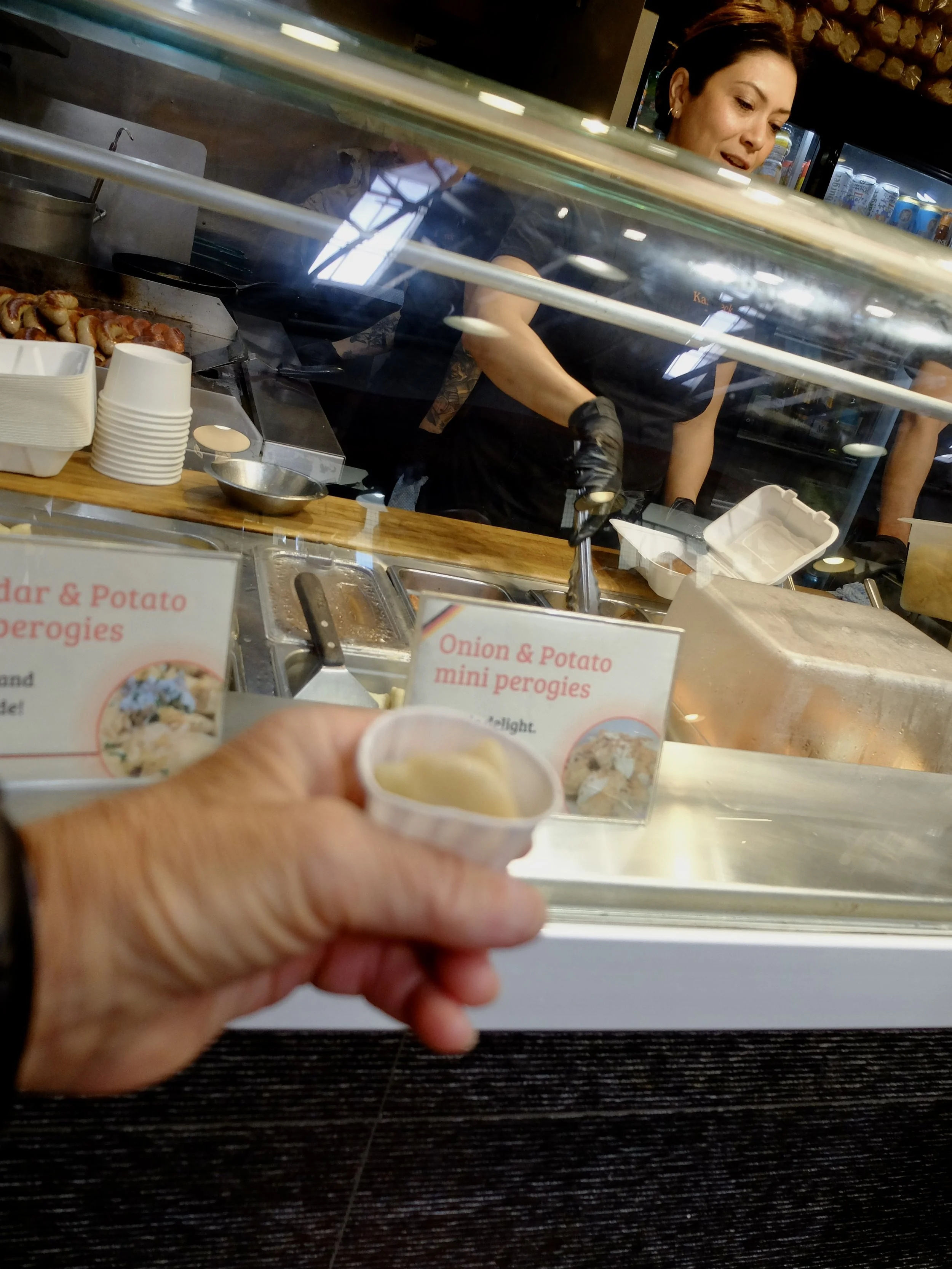  One of many samples to be tried at The Granville Island Public Market. At Roman’s Kaisereck Deli, she was delighted to give me this delicious mini perogi sample.  I later returned to this stand for an all beef sausage with sauerkraut &amp; a beer.  