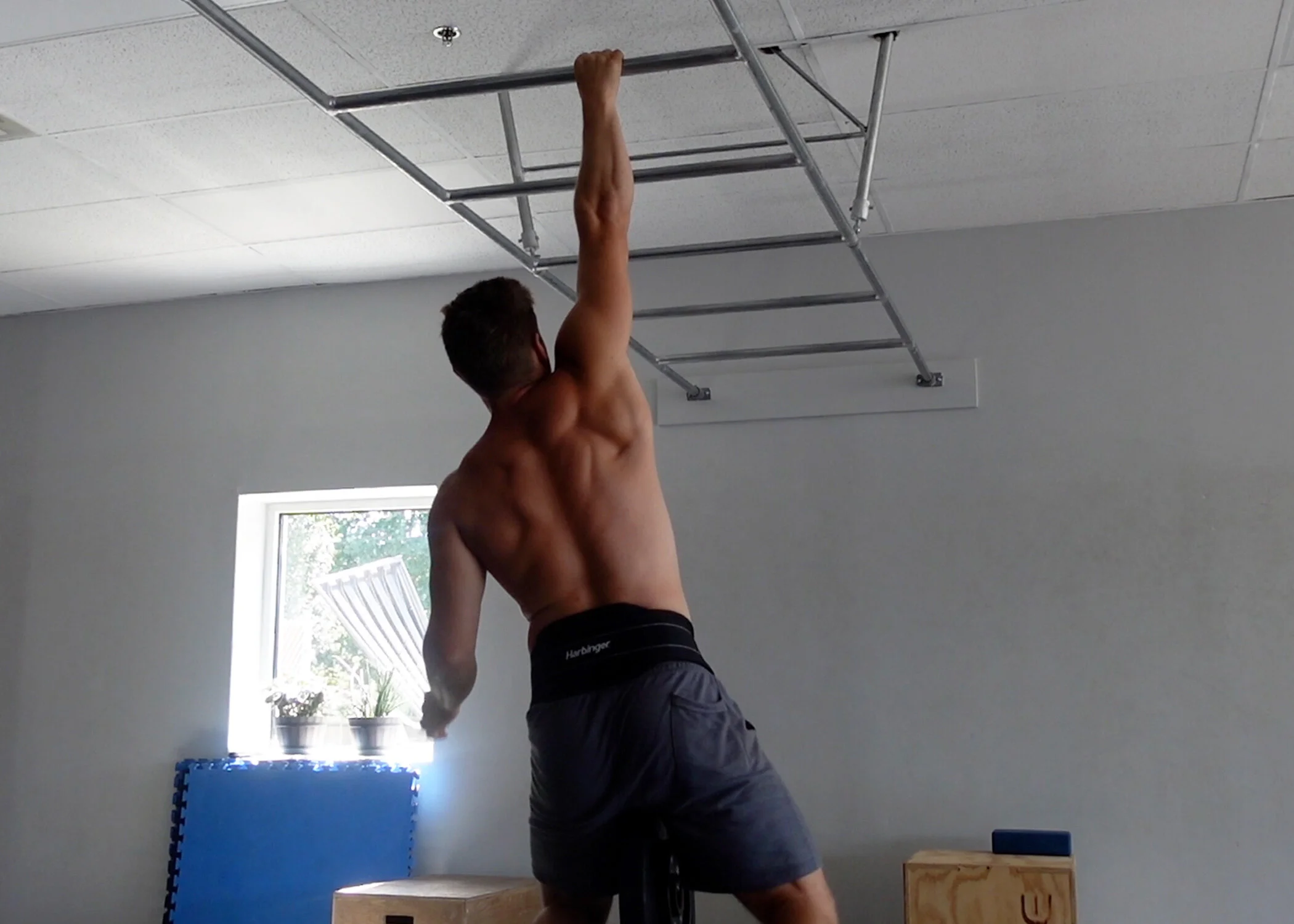 Performing weighted one arm pull ins. Note the pronated grip.