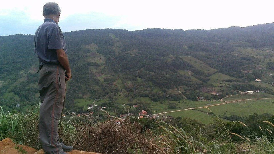 Joaquim, filho mais velho de Zeca, observa o vale do alto da plantação de cana de açúcar que abastece a produção da cachaça (Foto Jaxom Moore/Divulgação)