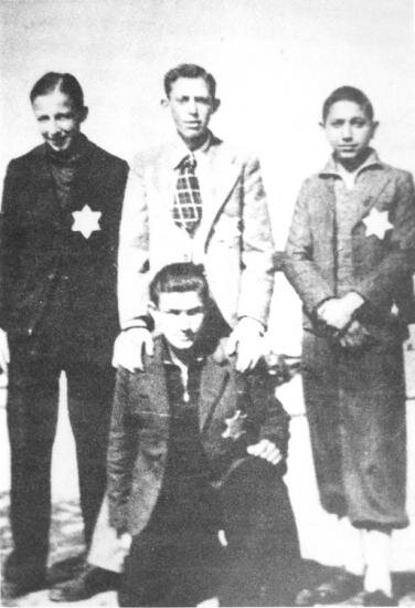David Zion (debout au centre) avec trois autres jeunes hommes avant leur déportation, Salonique
