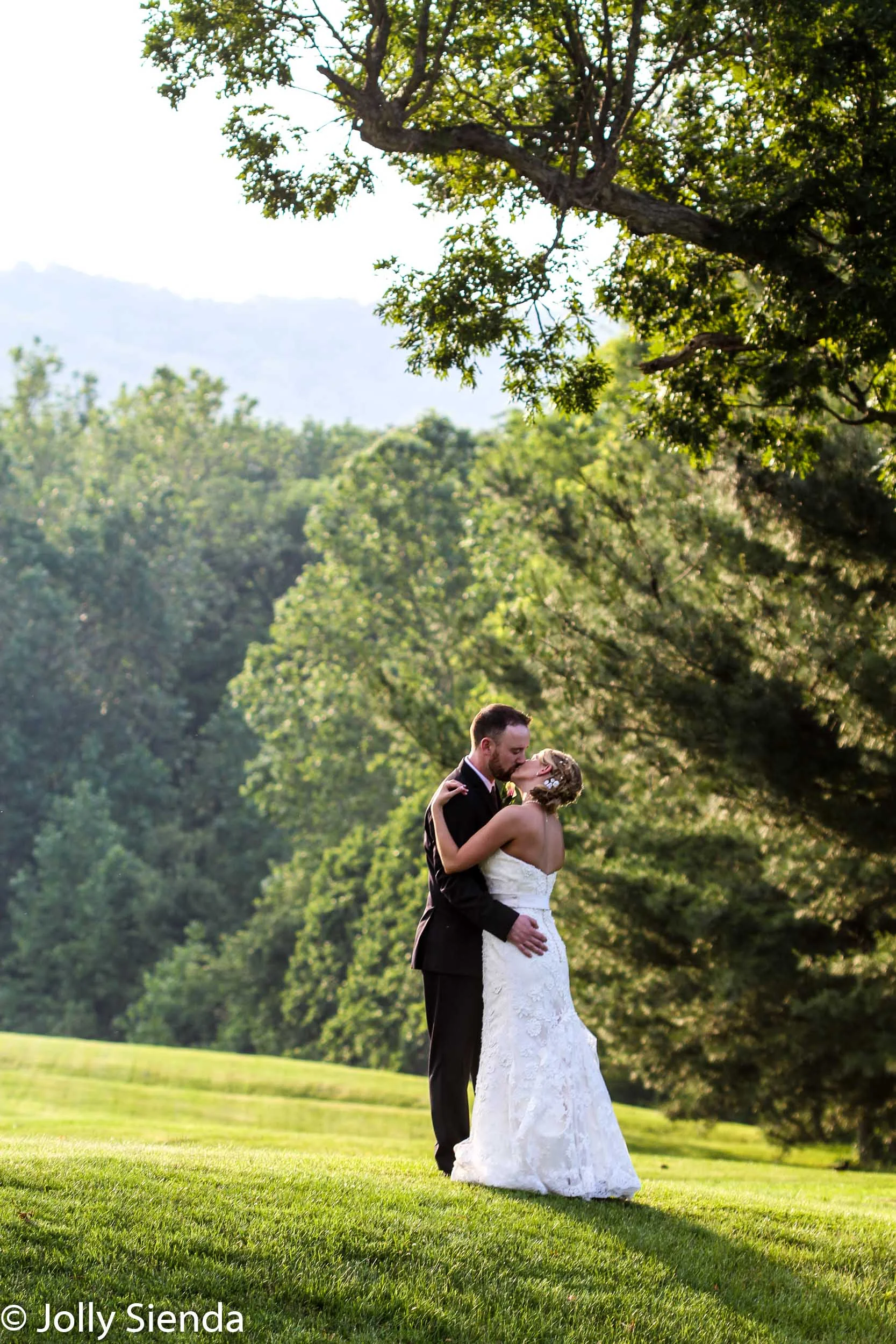 Portrait of a wedding couples kiss outside at a golf course unde