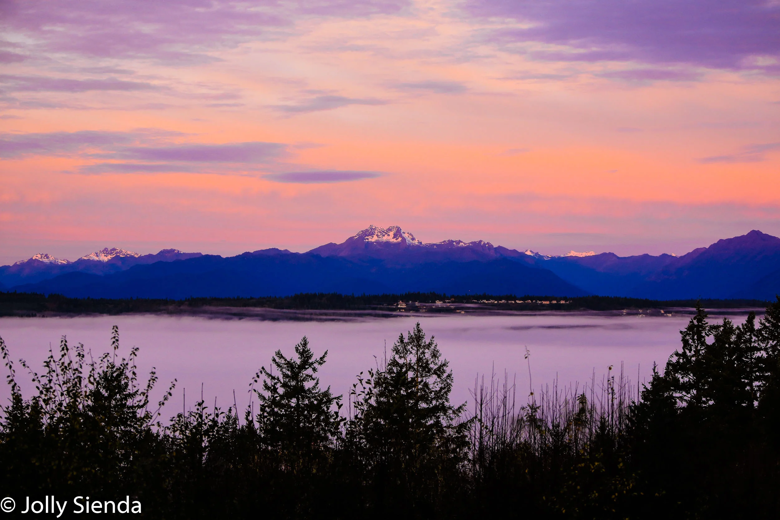 Fog, a sunrise, and the Olympic Mountains