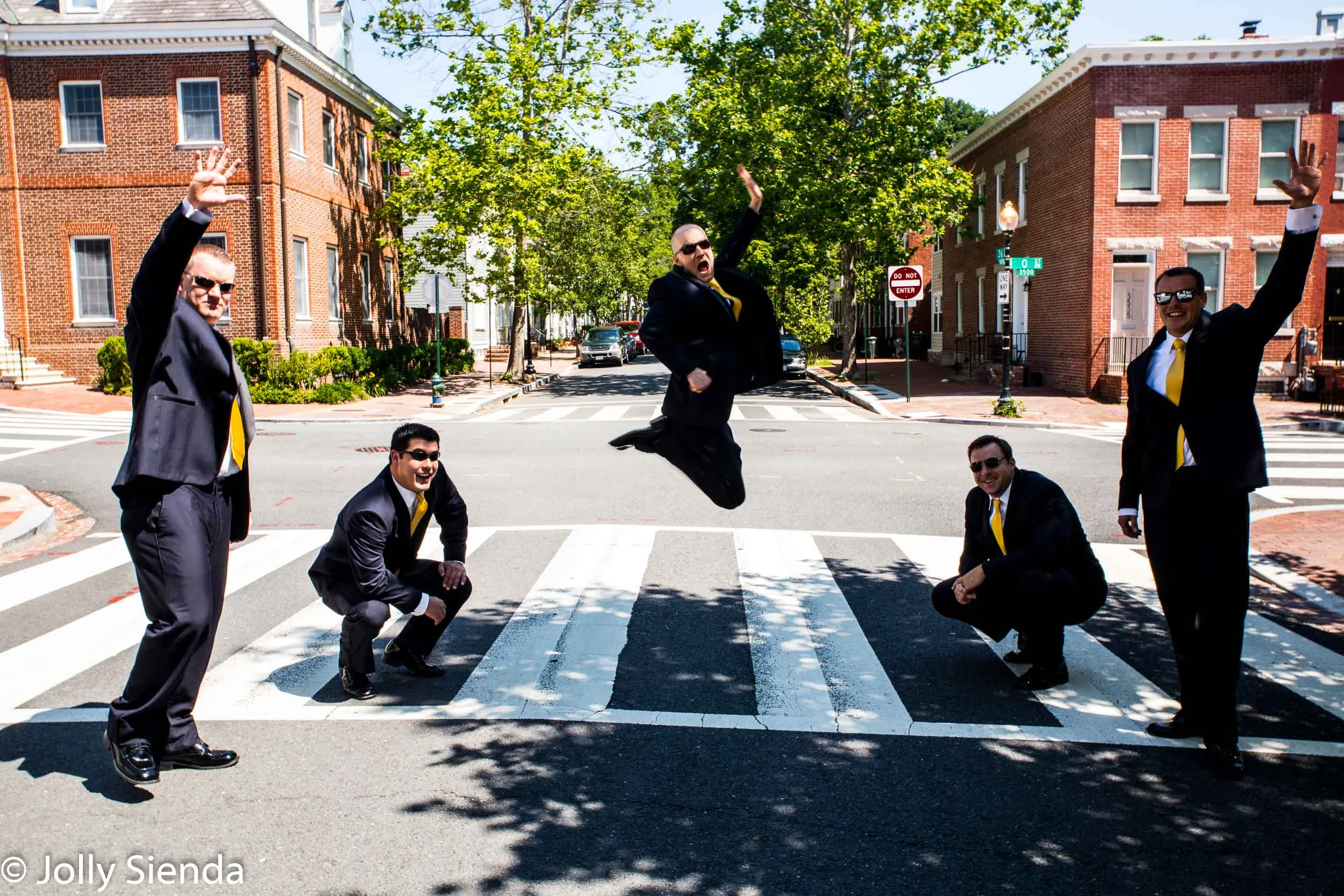 Portrait of a groom and his best men jumping in the street