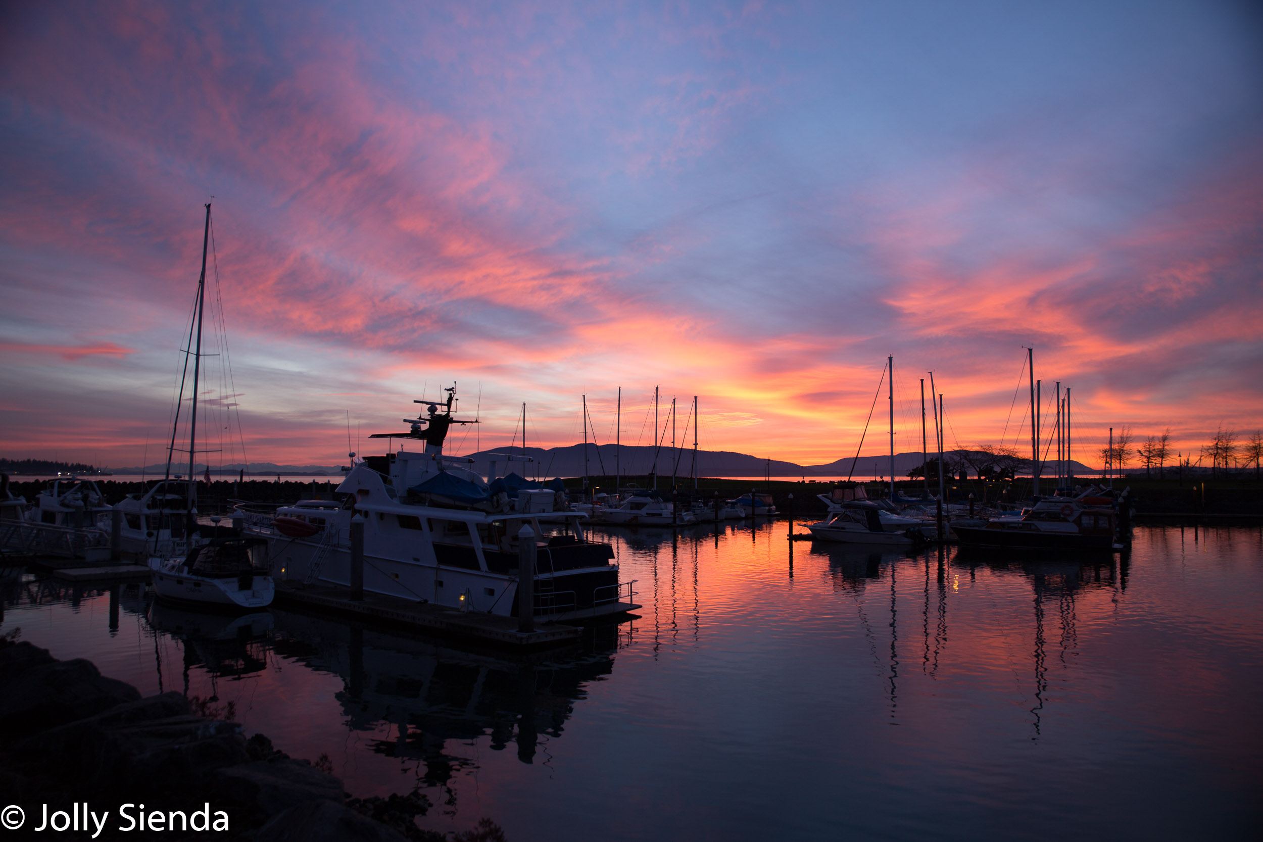 Pink sunset sets on a boat marina and Bellingham Bay