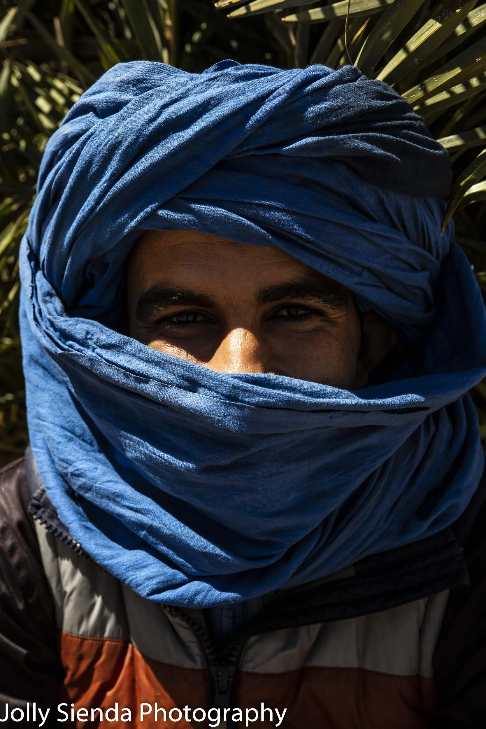 Man wears a blue turban and smiling eyes