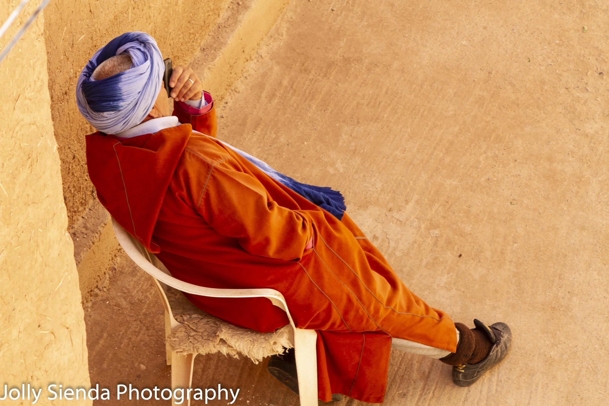 Man in a Jabala rests in a chair