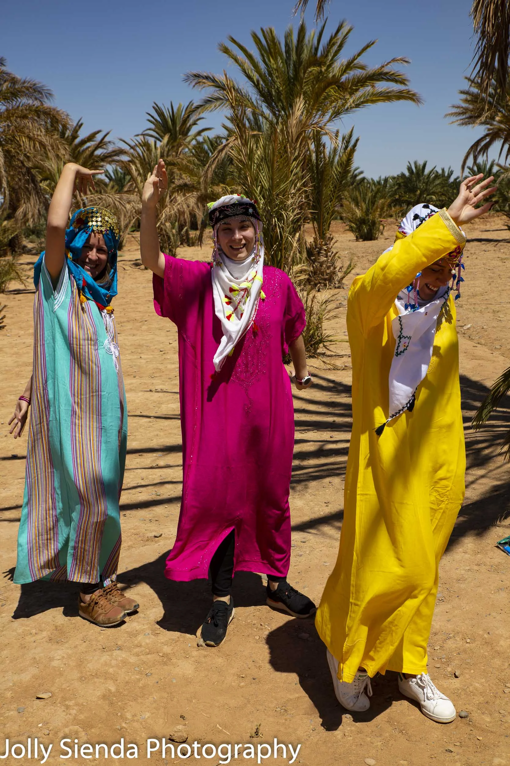 Female tourists dance and wear Moroccan caftens and head scarfs