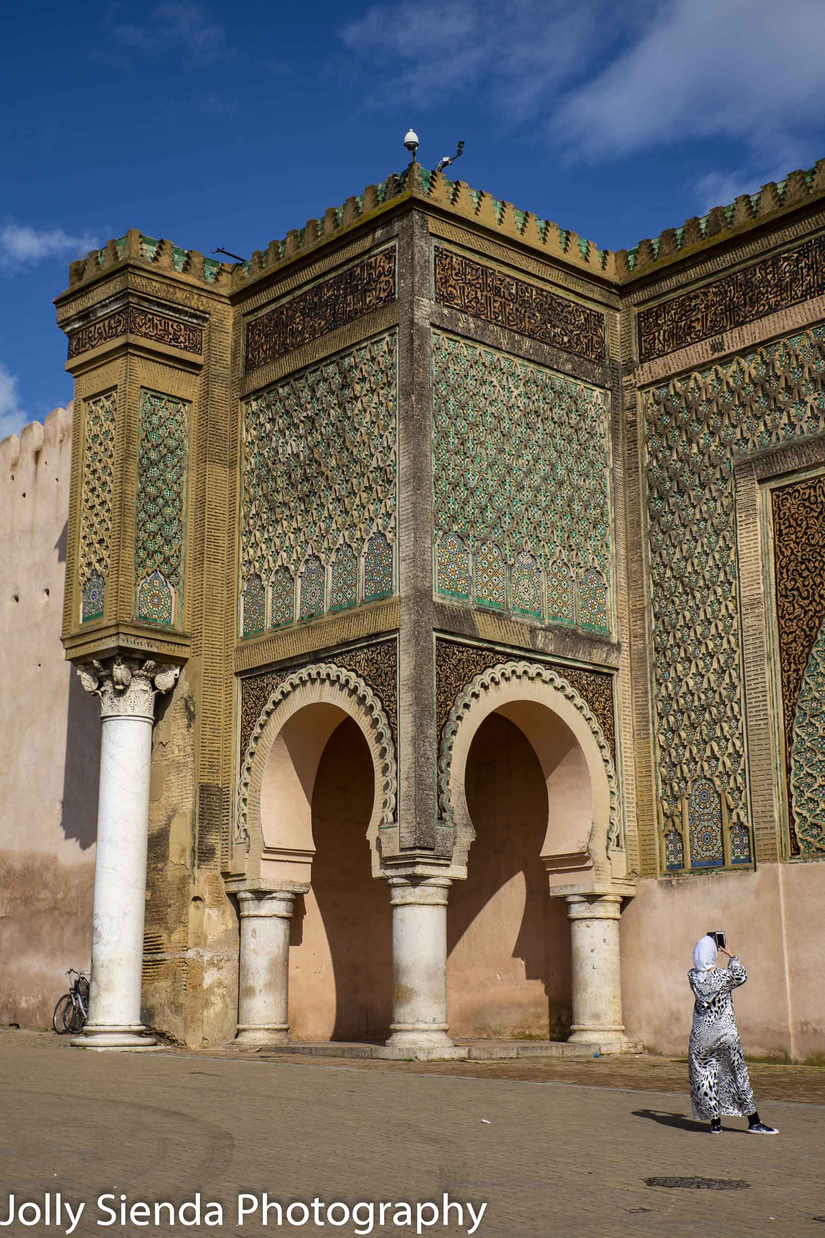 Muslim woman takes a picture of Bab al-Mansour mosaic tile