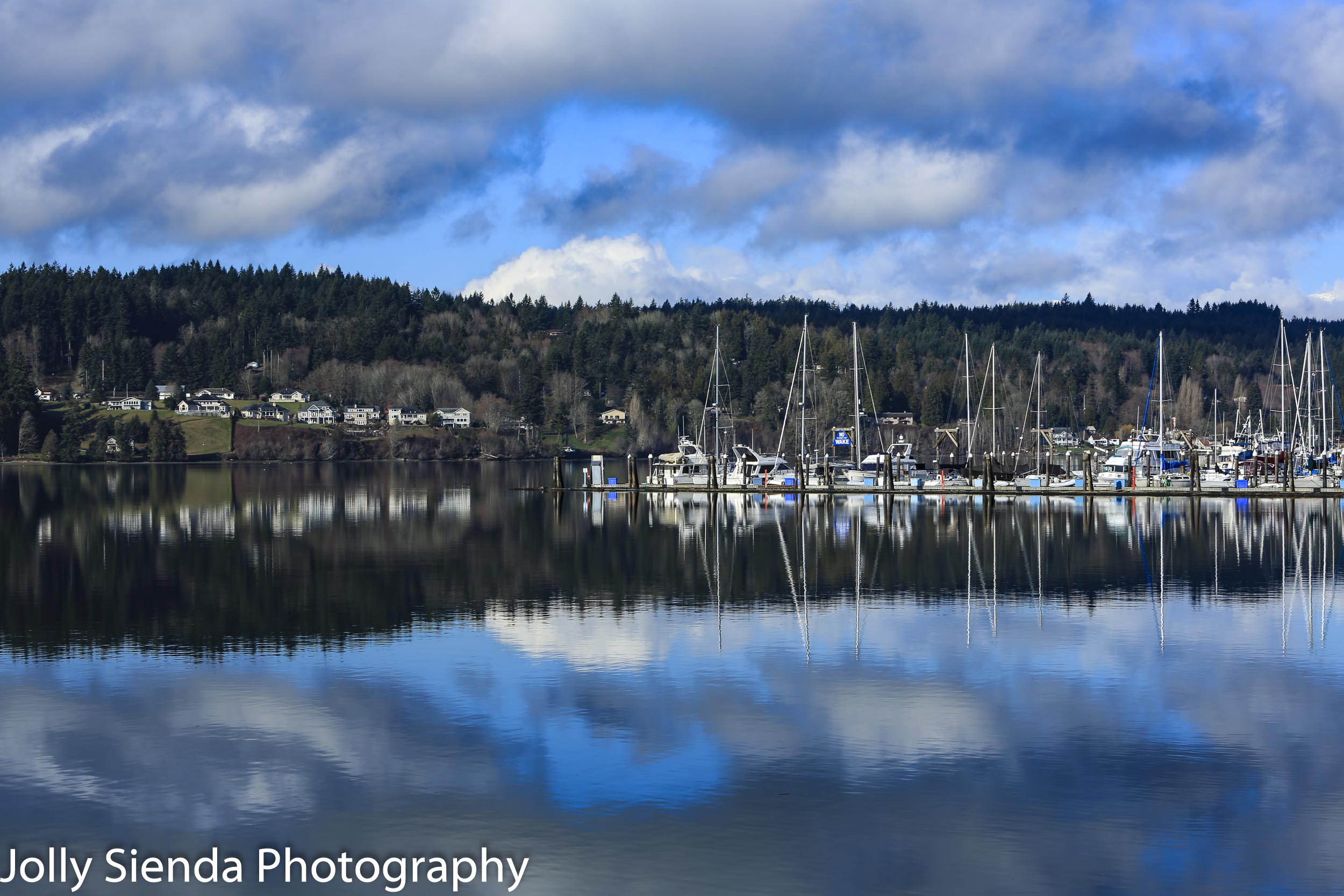 Reflection of clouds, waterfront, and boat marina on Liberty Bay