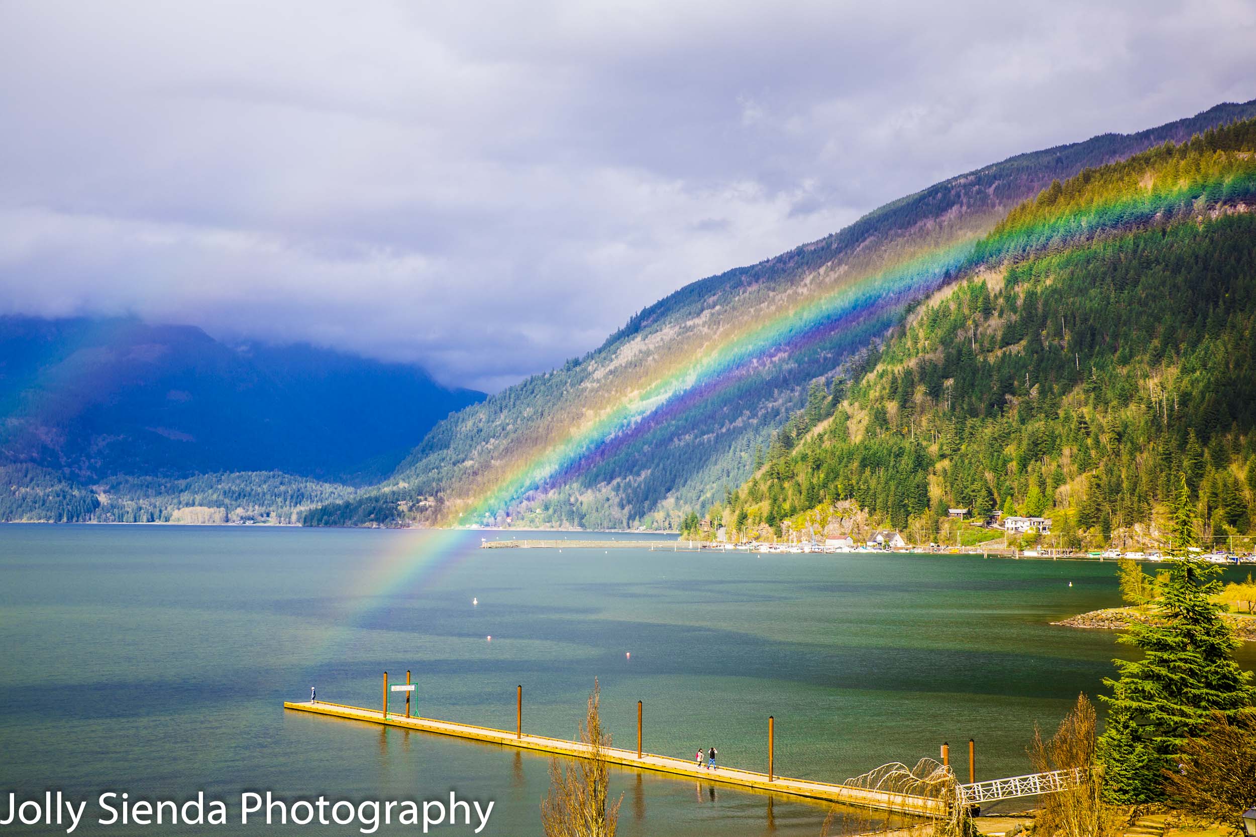 Rainbow arches over the dock and Harrison Lake