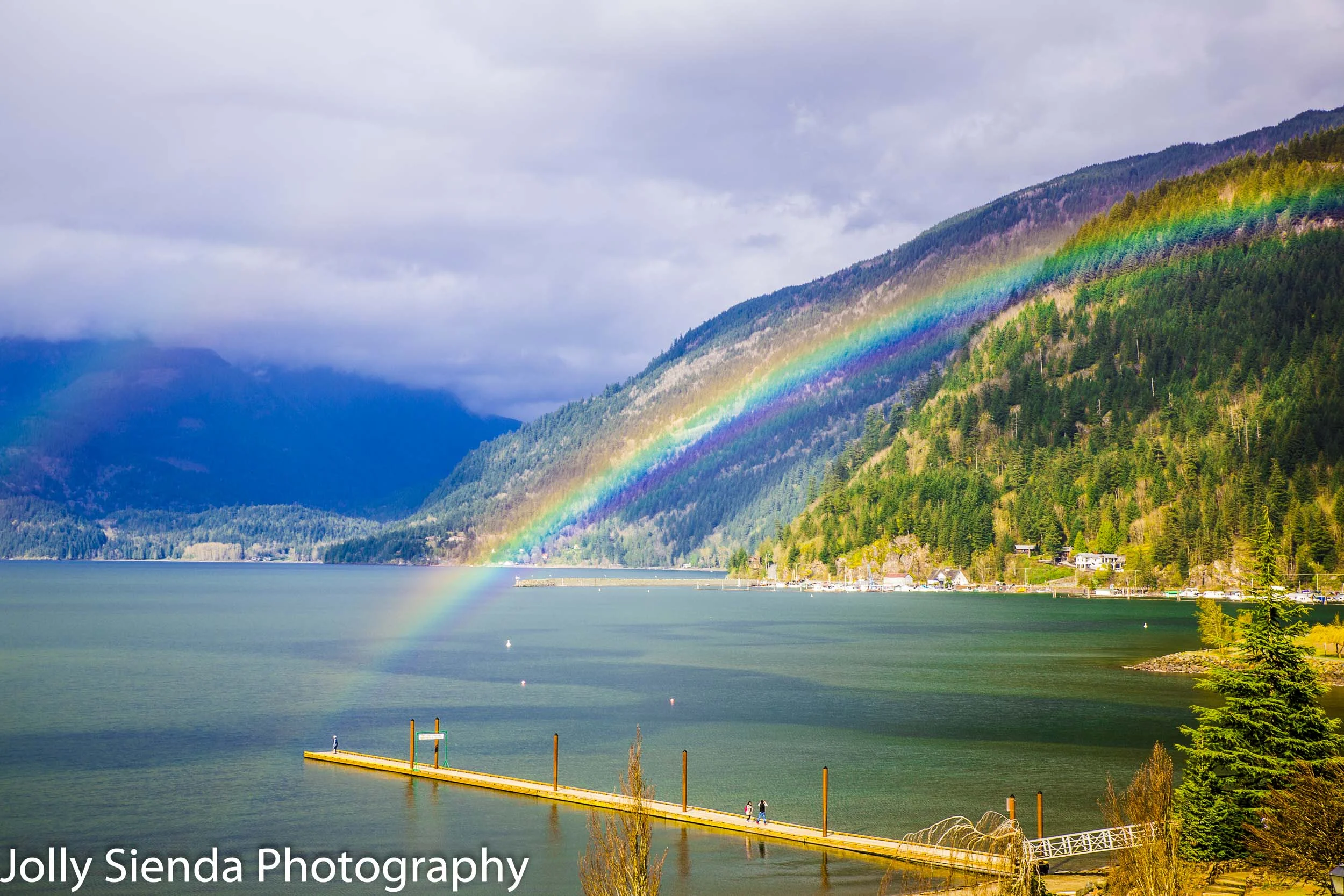 Rainbow arches over the dock and Harrison Lake