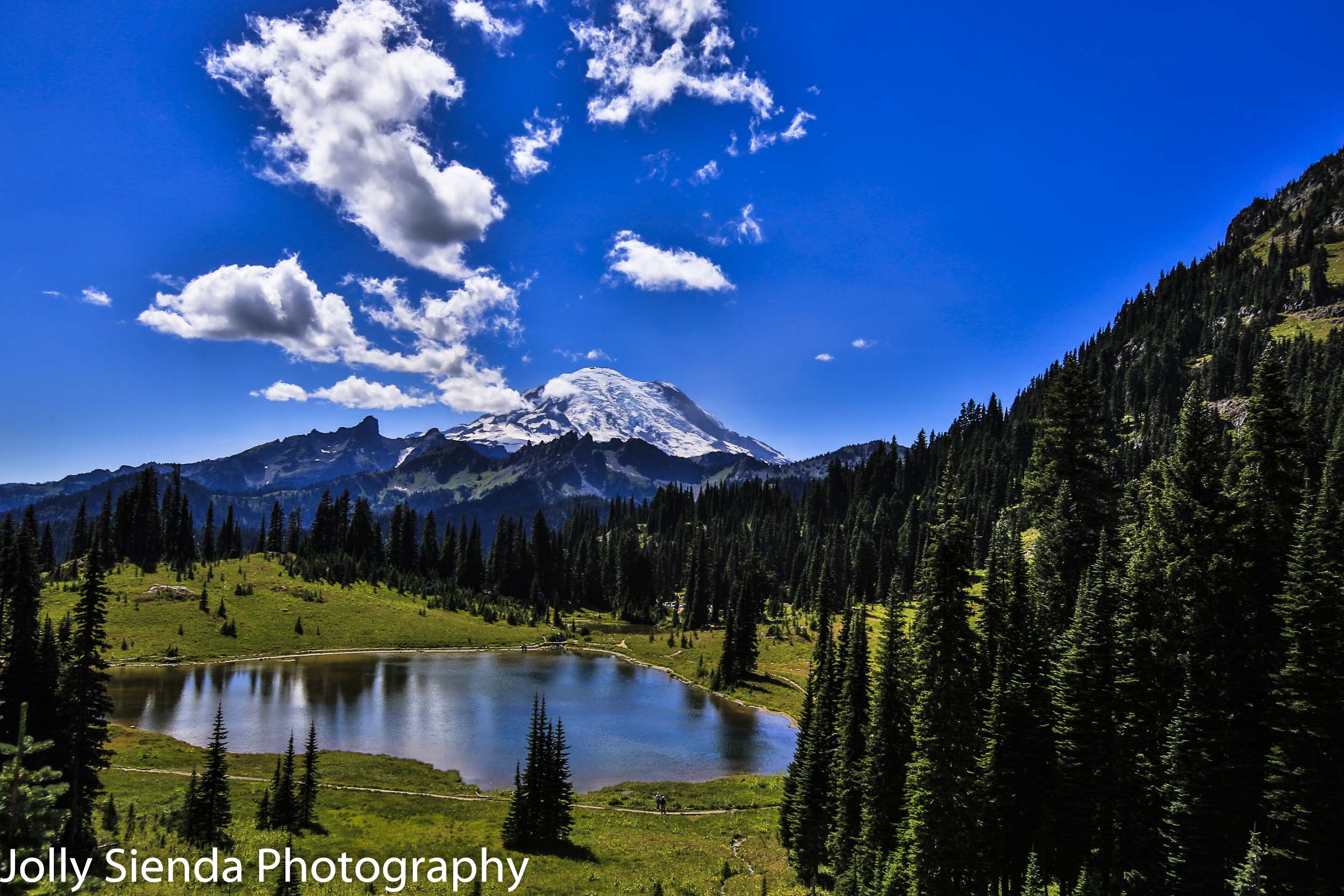 Mount Rainier, clouds, evergreen trees, lake at summertime