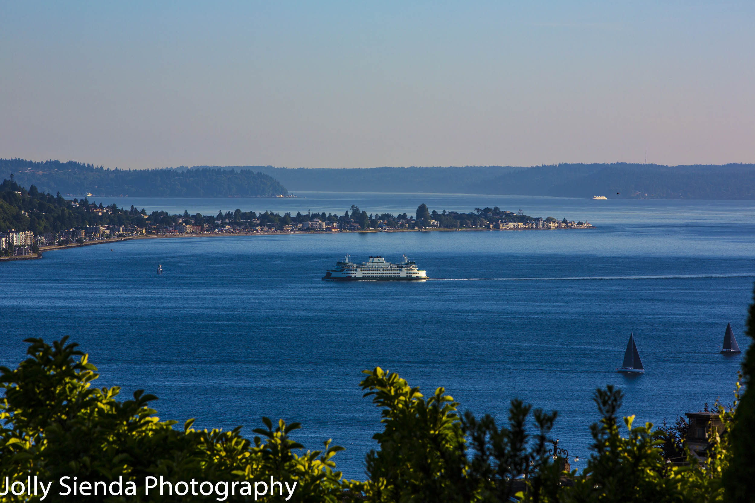 Ferry and sailboats on Elliott Bay passing West Seattle