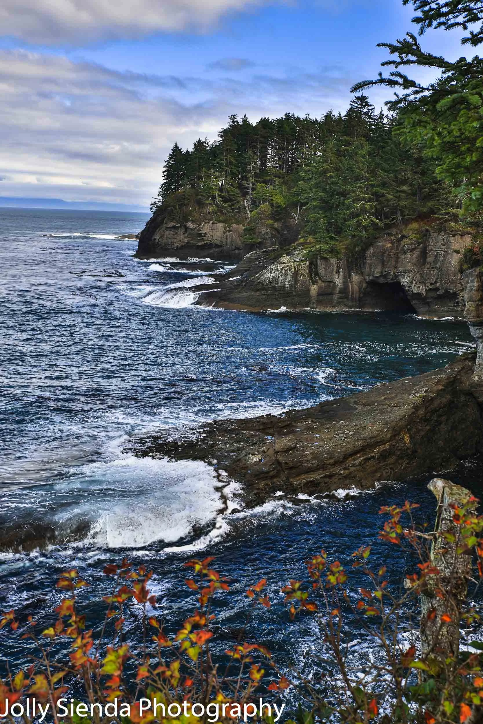 Caves and bluffs at Cape Flattery with water crashing onto the b