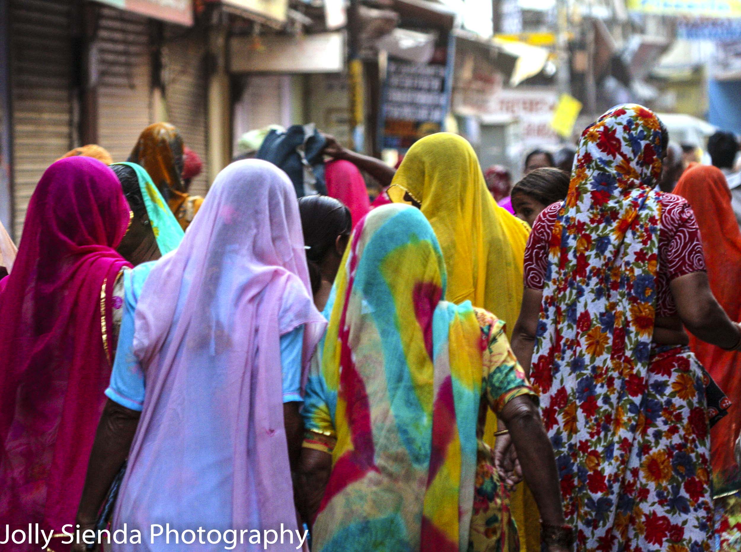 Crowd of women wearing colorful sari's walking in the market