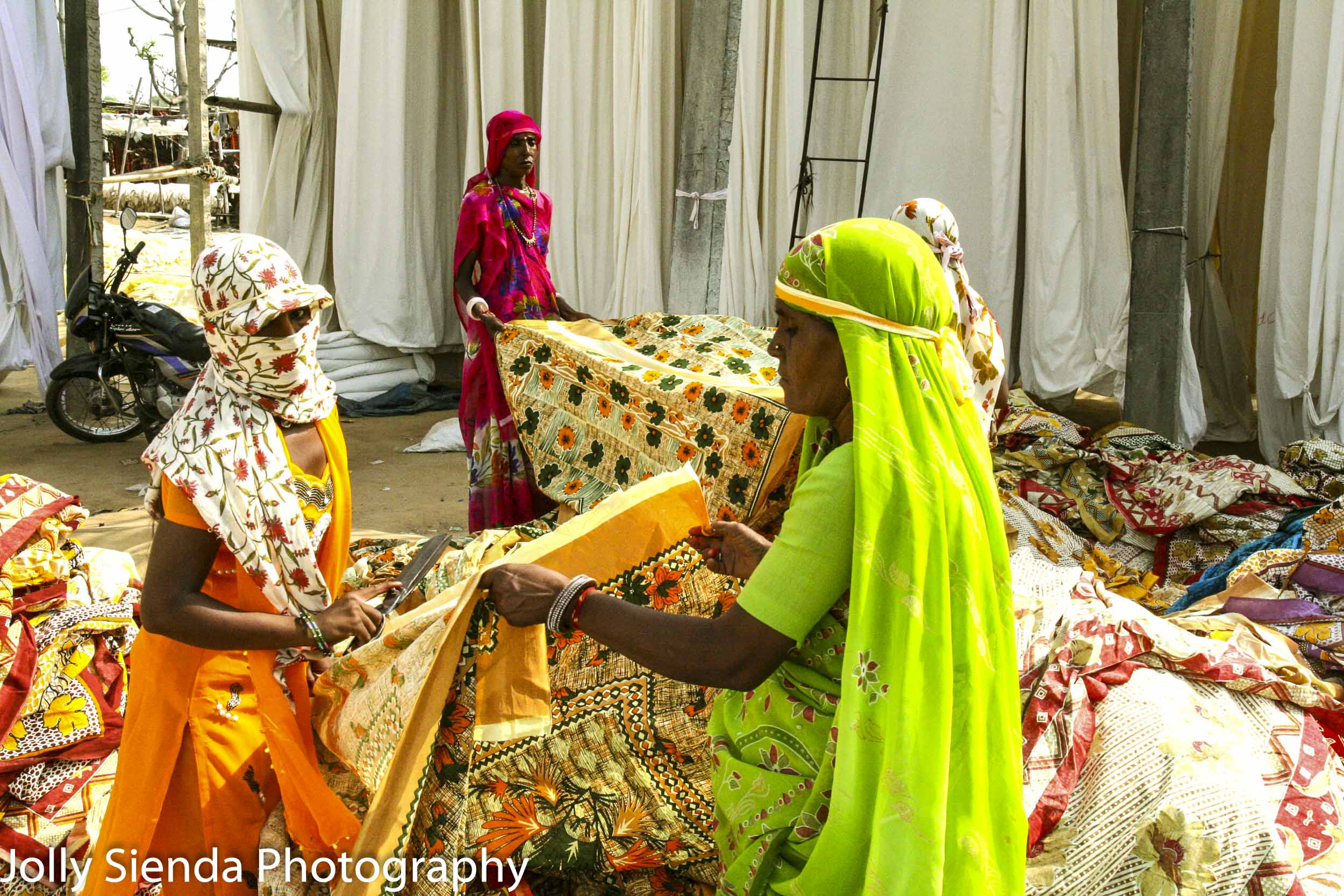 Women working with dyed cotton material at a block printing fact