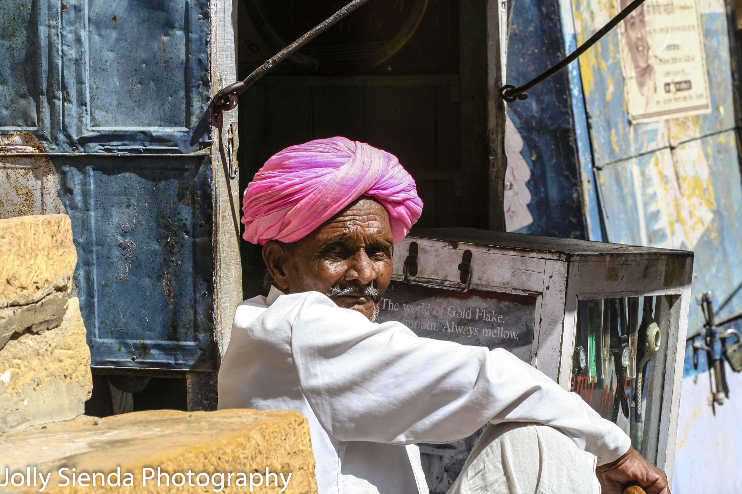 Man sitting wearing a pink turban