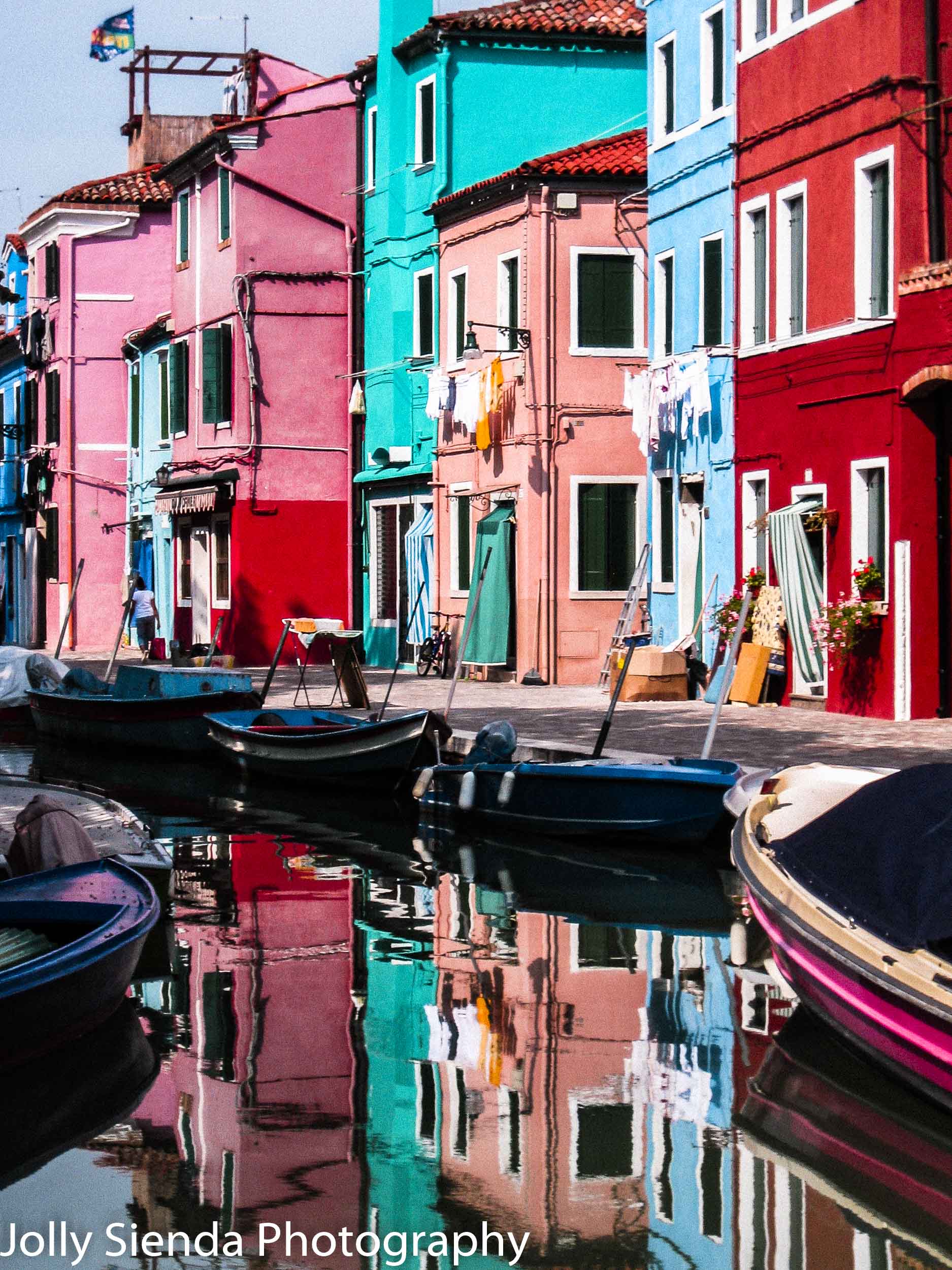 Burano's Colored Houses, on a canal, with colored boats and a re