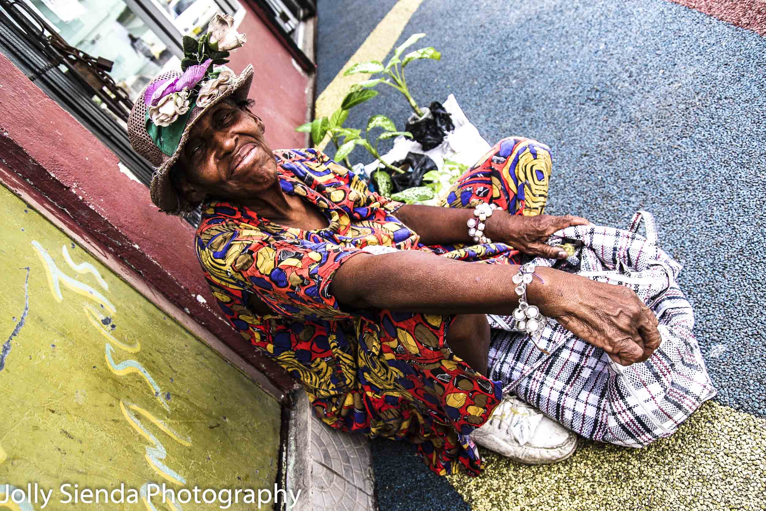 Old woman sells plants on the sidewalk