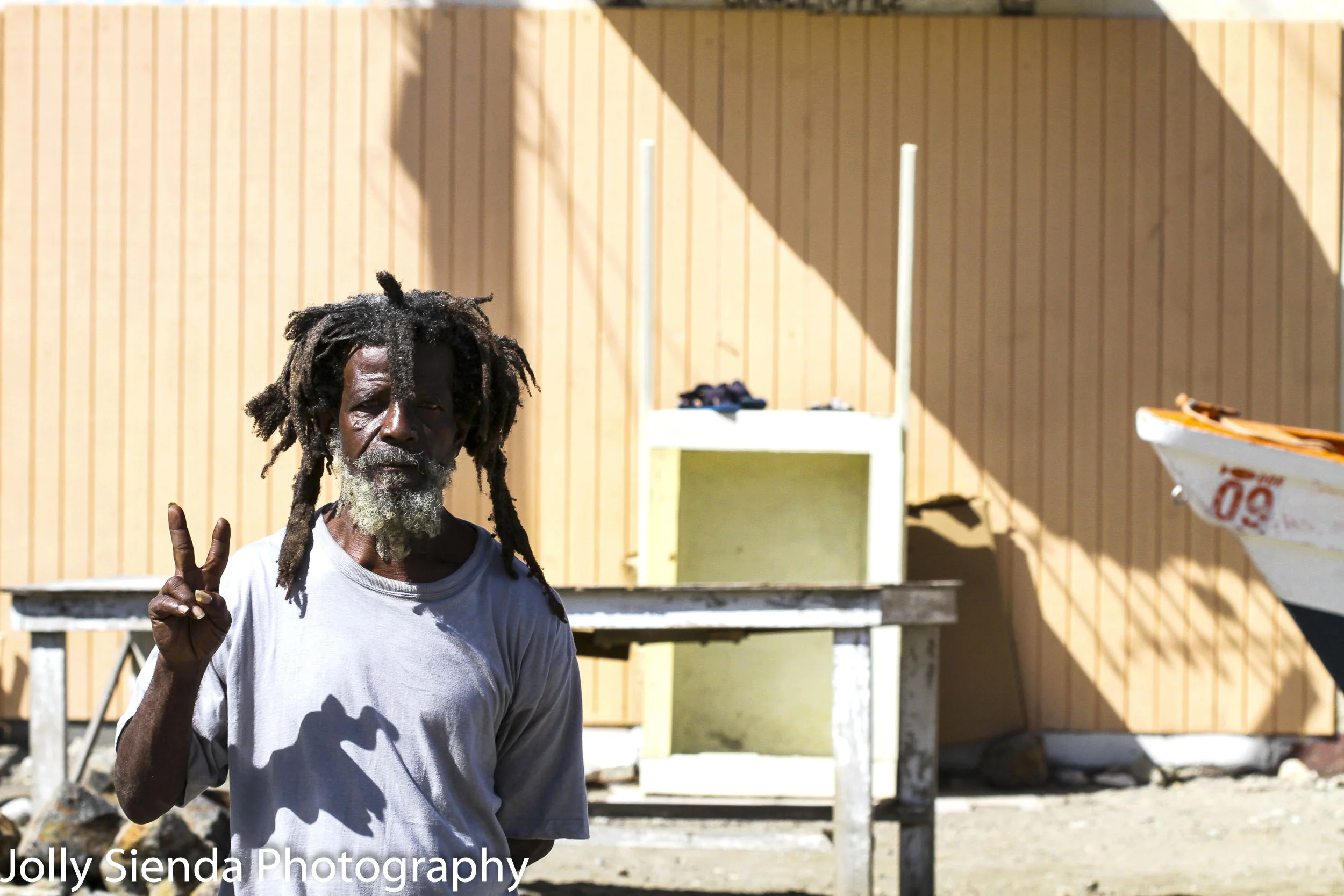 Portrait of a Rastafarian man making a peace sign with his hand