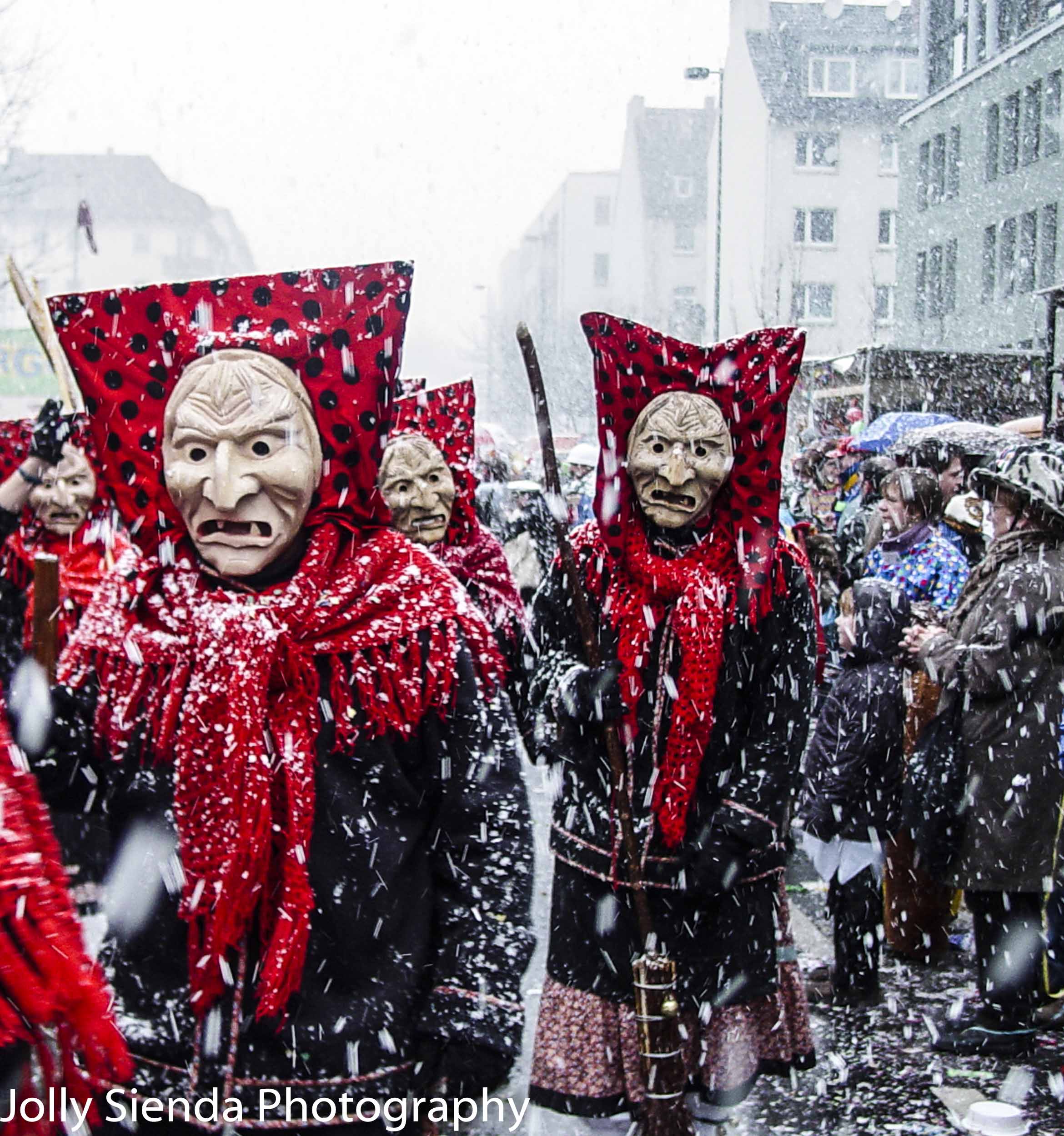Costumed witches in red polka dots costumes walk in the snow at 