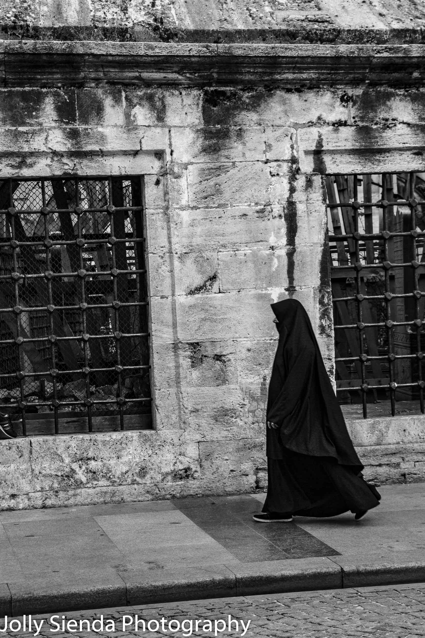 Woman walking on the street wearing a Hijab and Burqa