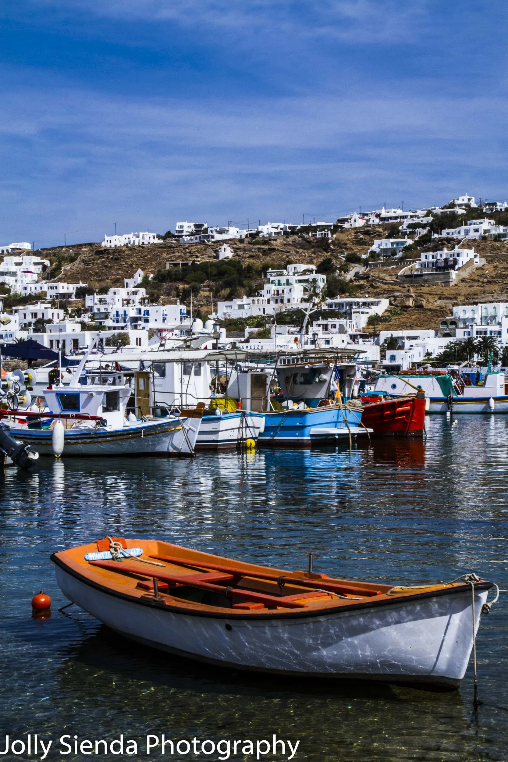 Orange boat floats at Mykonos harbor