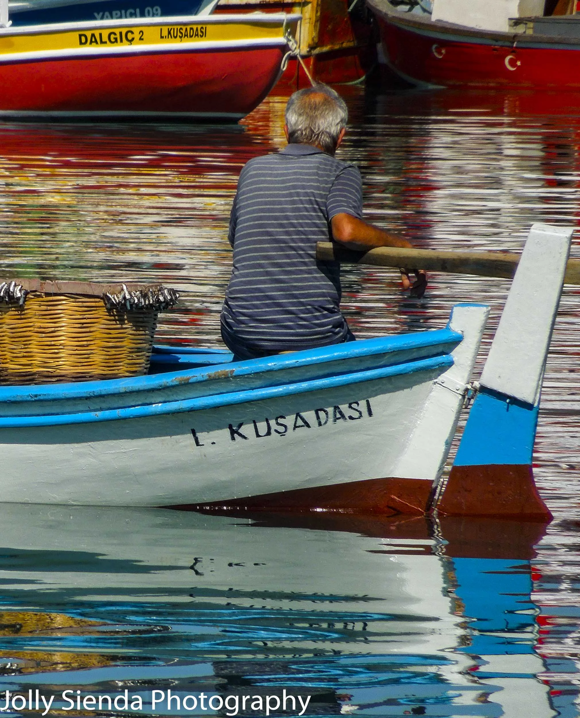 Fisherman rests on his wooden boat