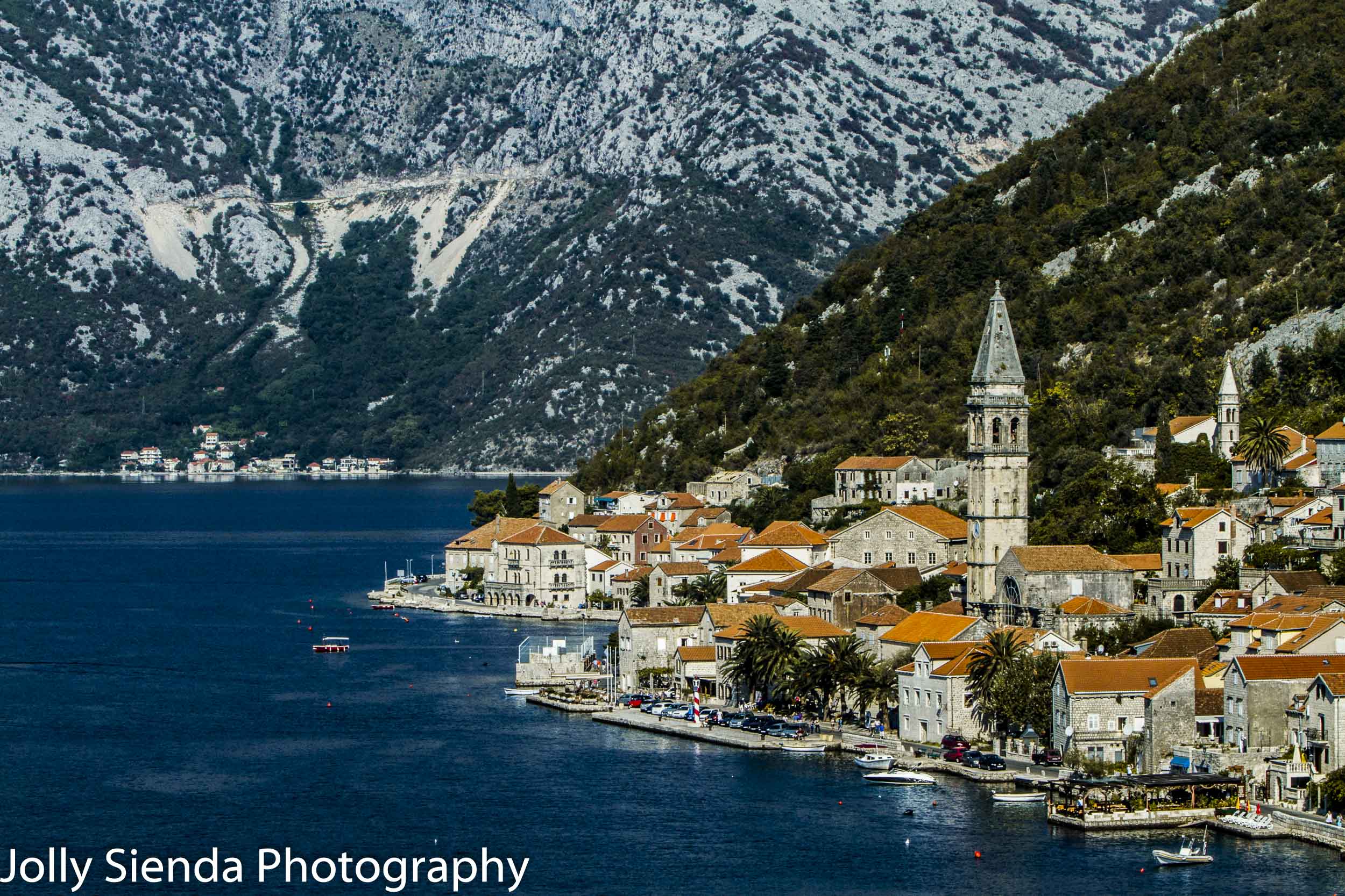 Orange tiled roofs, church and a village waterfront, Tivat, East