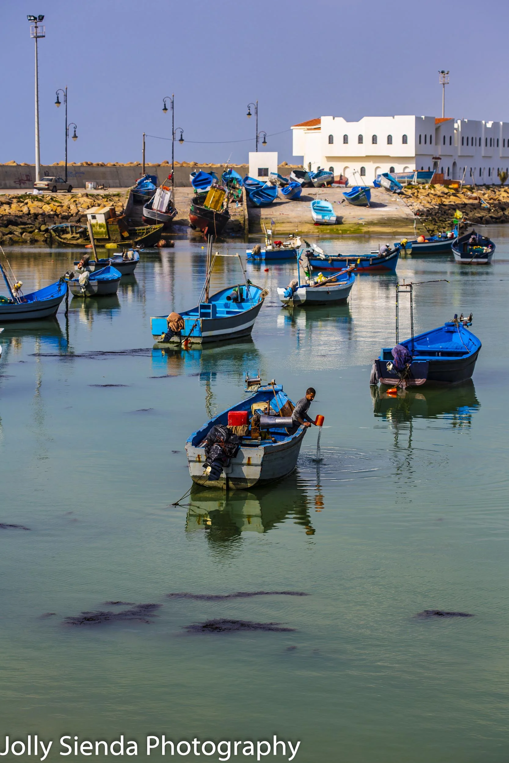 Fisherman empties pail from the boat