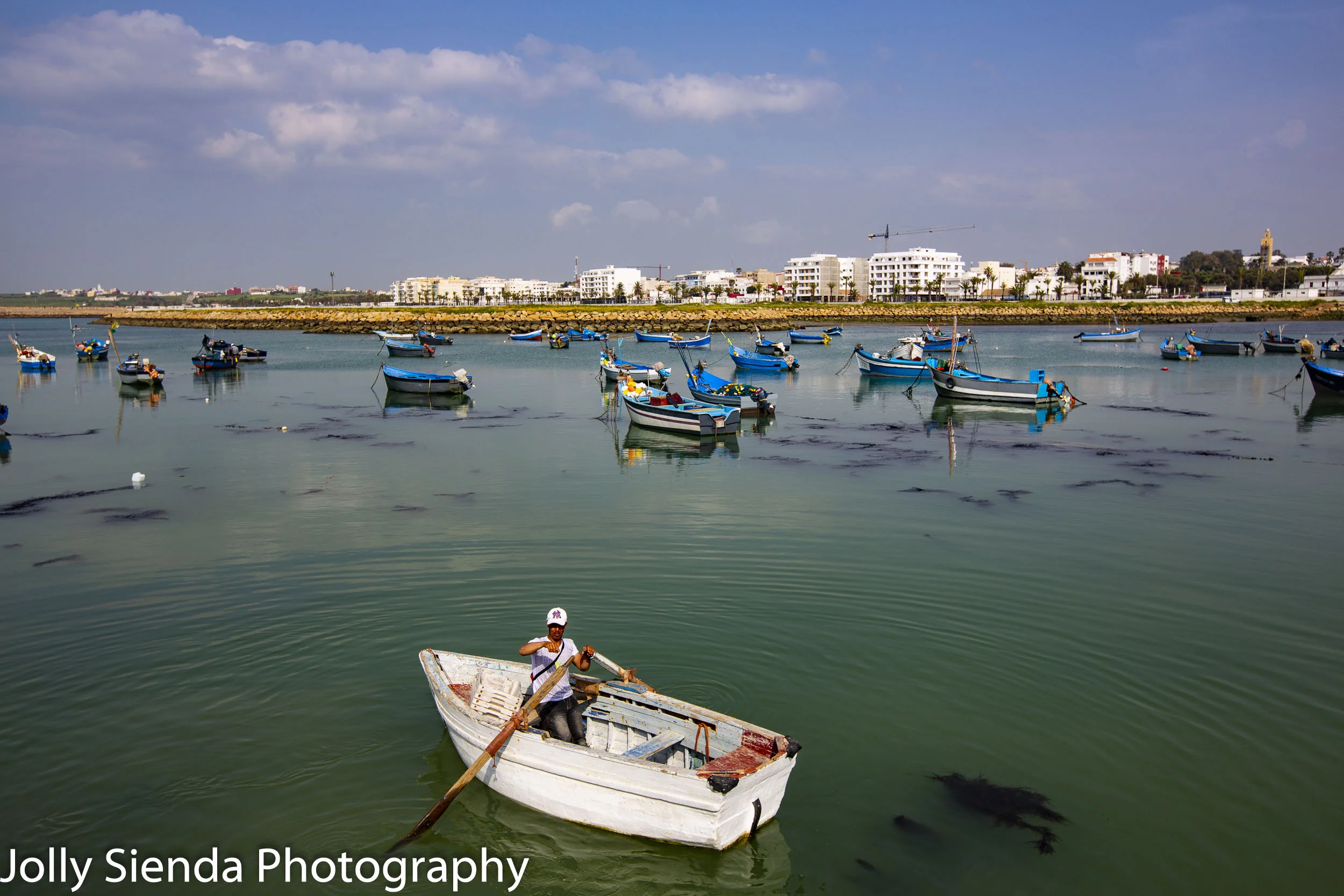 Fisherman and wooden blue boats