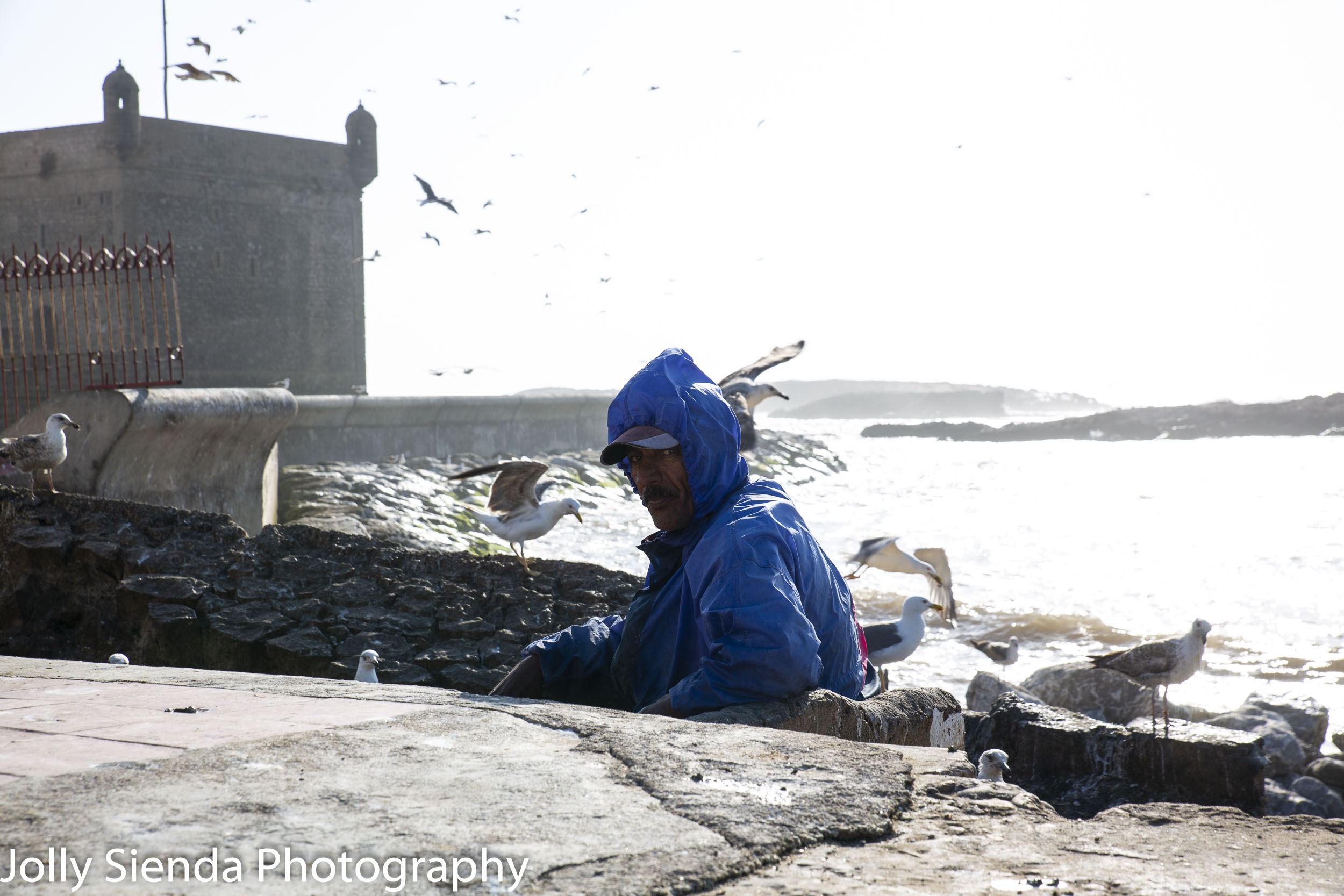 Fisherman wears blue raincoat at Essaouira fishing port