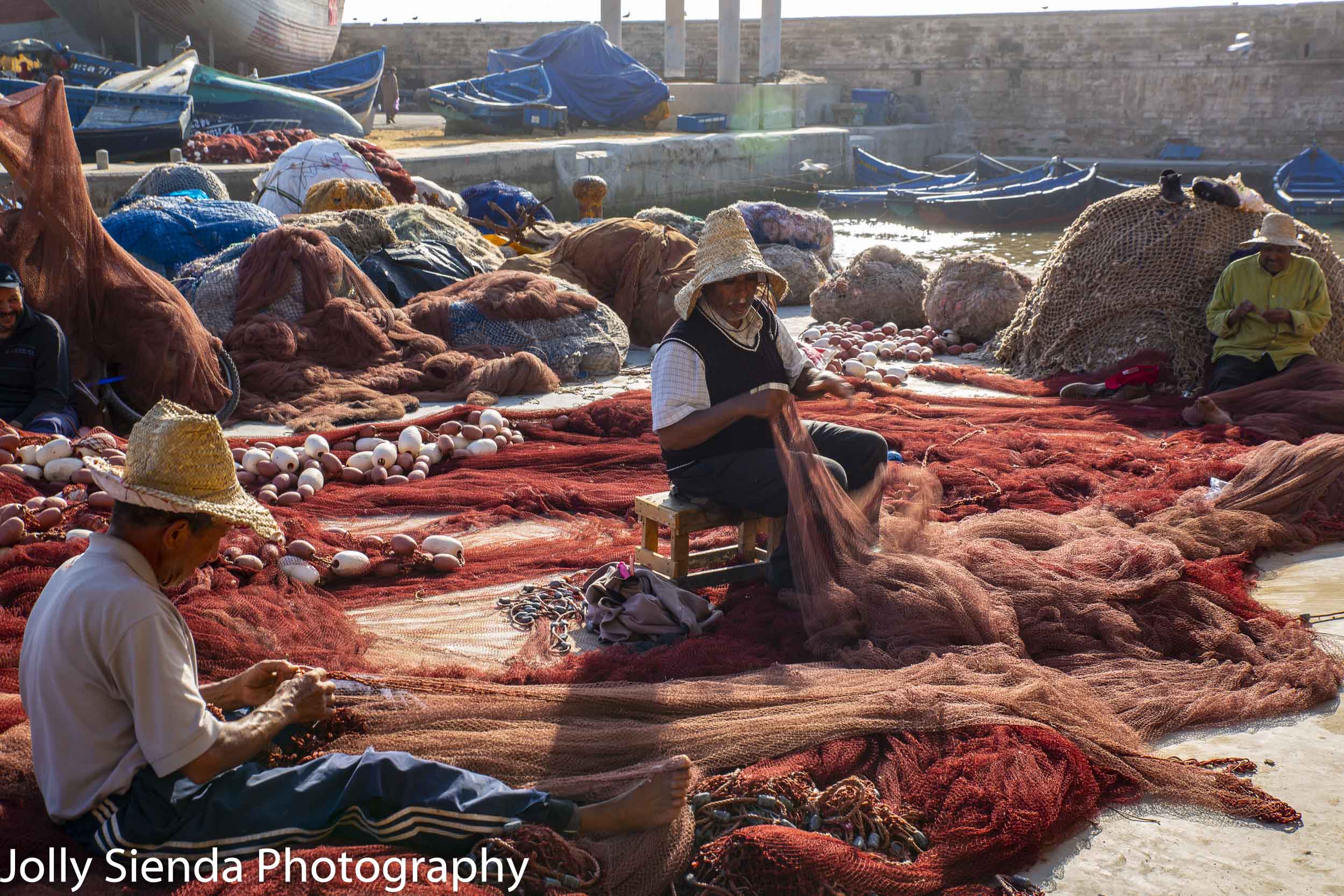 Fishermen repair fish nets