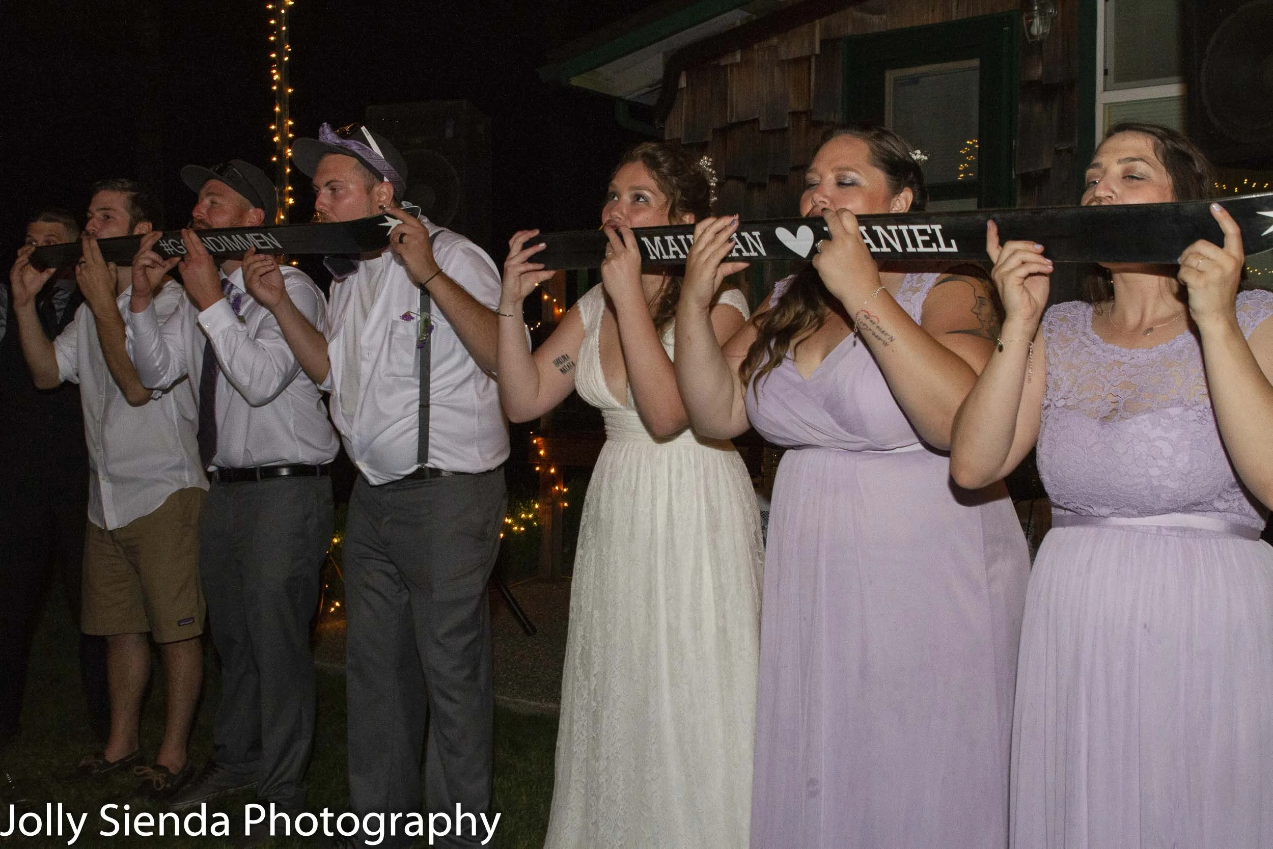 Dan Dimmen and Maurean Dimmen celebrate their wedding night with friends at their wedding reception drinking shots from skies, outside under the stars!