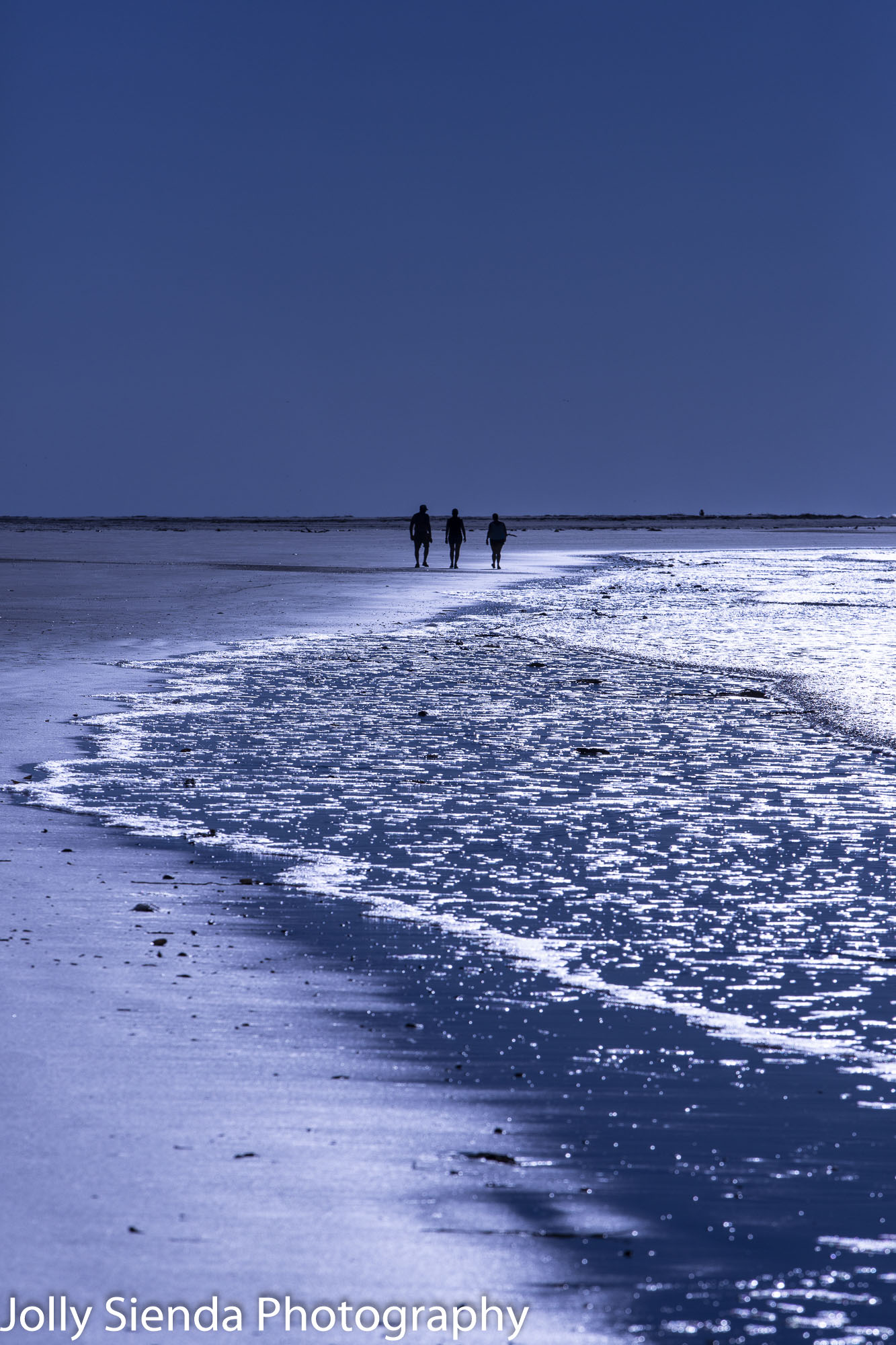 People walking the beach at sunrise