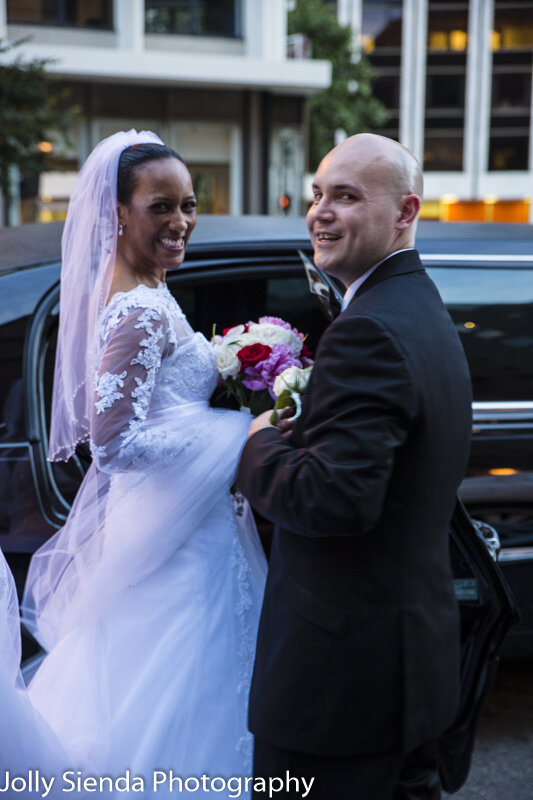 Portrait of a bride and groom with their limousine